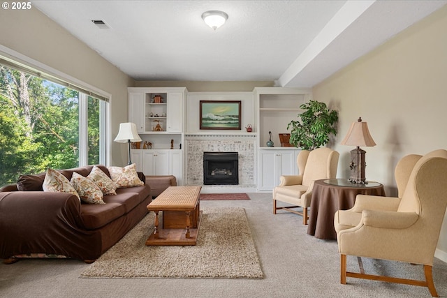 living area featuring carpet and a tile fireplace
