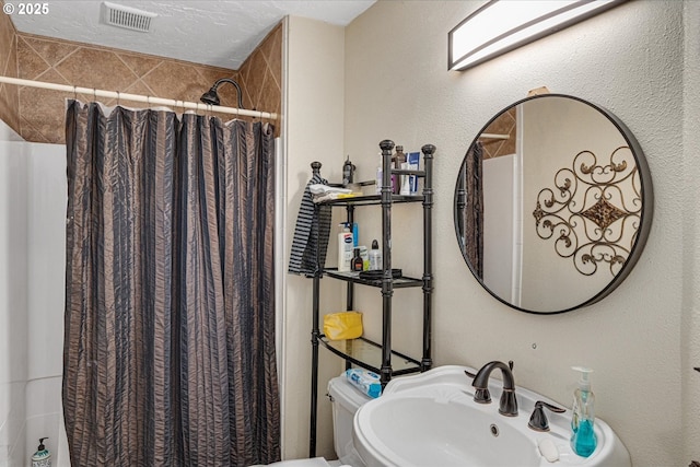 full bath featuring a sink, curtained shower, and toilet