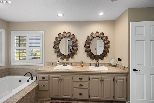 bathroom with a garden tub, double vanity, and recessed lighting
