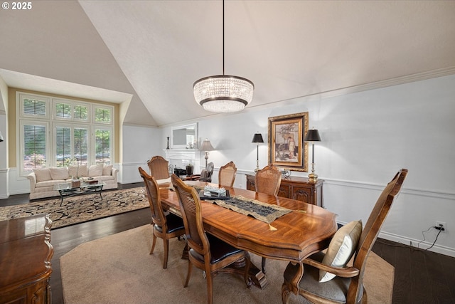 dining space with a chandelier, wood finished floors, and vaulted ceiling