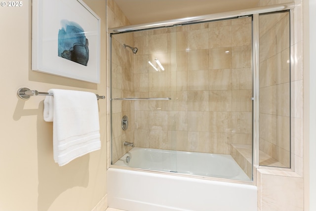 bathroom with bath / shower combo with glass door