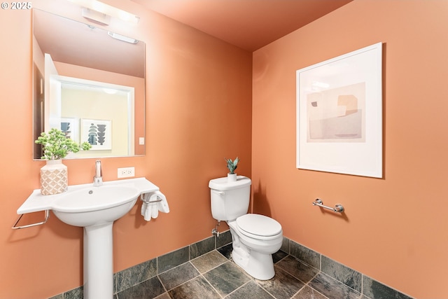 half bath with toilet and baseboards