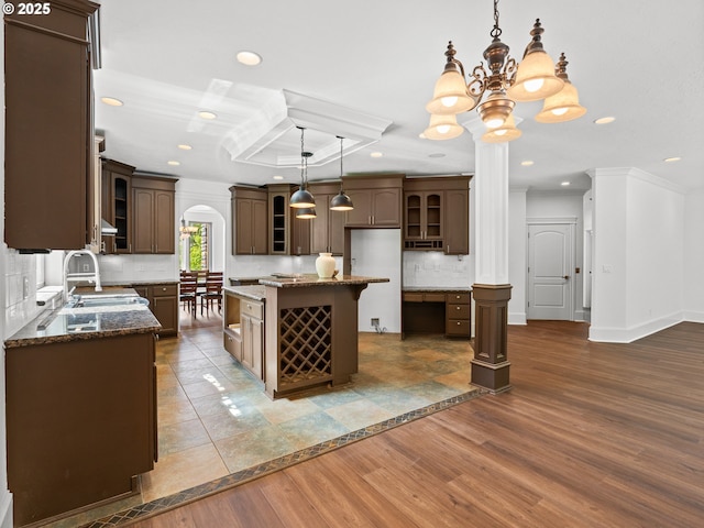 9540 SE Spyglass Dr, Happy Valley, OR 97086 - kitchen with dark brown cabinets, a sink, dark stone countertops, recessed lighting, and glass insert cabinets