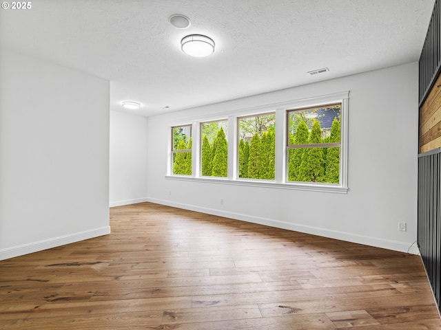 9540 SE Spyglass Dr, Happy Valley, OR 97086 - unfurnished room featuring a textured ceiling, baseboards, visible vents, and hardwood / wood-style flooring