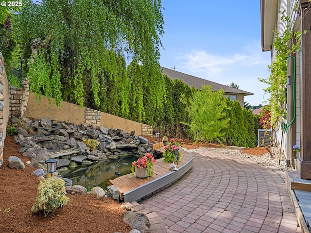 9540 SE Spyglass Dr, Happy Valley, OR 97086 - view of patio / terrace featuring a garden pond and central AC unit