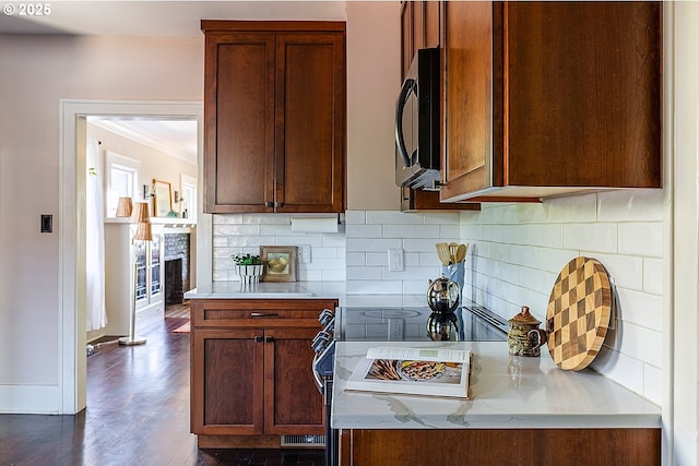 4915 NE 8th Ave, Portland, OR 97211 - kitchen with black microwave, decorative backsplash, crown molding, dark wood-type flooring, and a fireplace