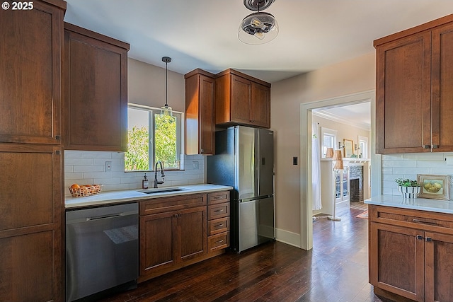 4915 NE 8th Ave, Portland, OR 97211 - kitchen with appliances with stainless steel finishes, light countertops, tasteful backsplash, dark wood-style flooring, and decorative light fixtures