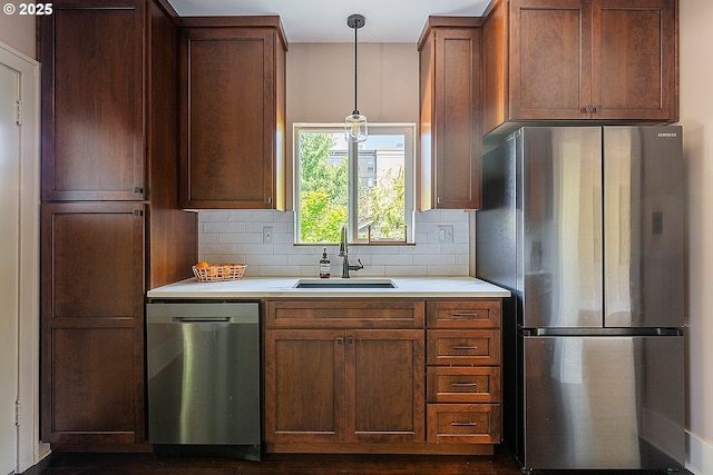 4915 NE 8th Ave, Portland, OR 97211 - kitchen featuring appliances with stainless steel finishes, light countertops, backsplash, and pendant lighting