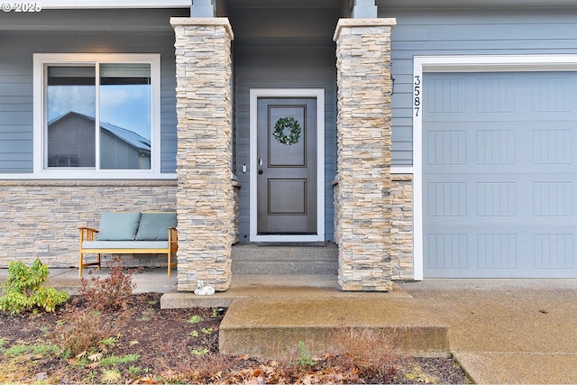 property entrance featuring a garage and stone siding