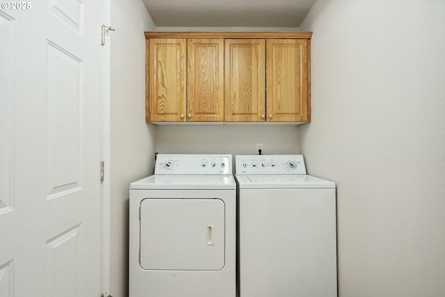 washroom with washing machine and dryer and cabinet space