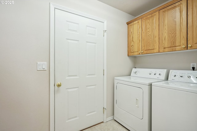washroom featuring light tile patterned floors, washer and dryer, and cabinet space