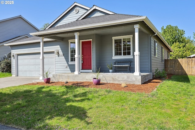 ranch-style home featuring fence, covered porch, a front yard, and a garage