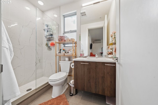 bathroom with visible vents, tile patterned flooring, vanity, toilet, and a marble finish shower
