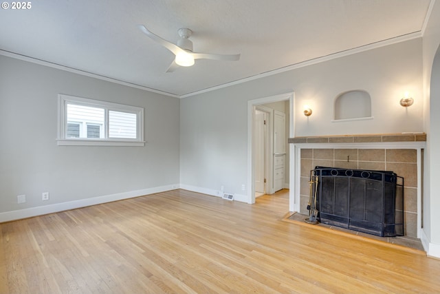 unfurnished living room with ceiling fan, ornamental molding, a fireplace, and wood-type flooring