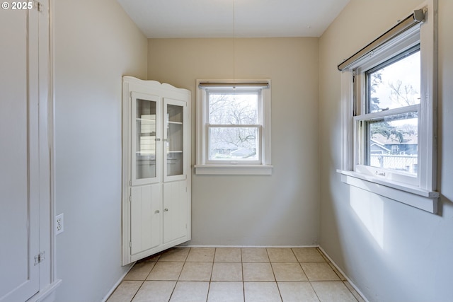 spare room featuring light tile patterned flooring and a wealth of natural light