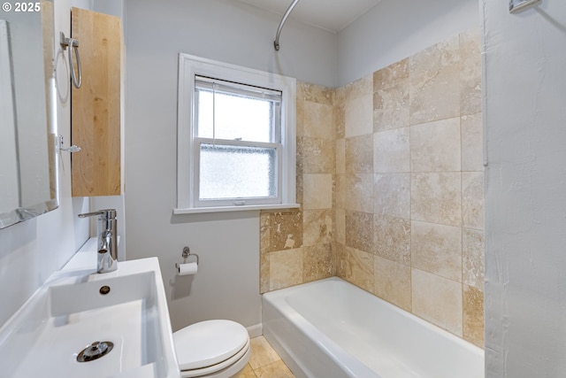 full bathroom with tiled shower / bath, tile patterned floors, toilet, and sink