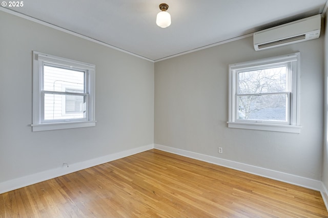 empty room with ornamental molding, light hardwood / wood-style flooring, and a wall unit AC