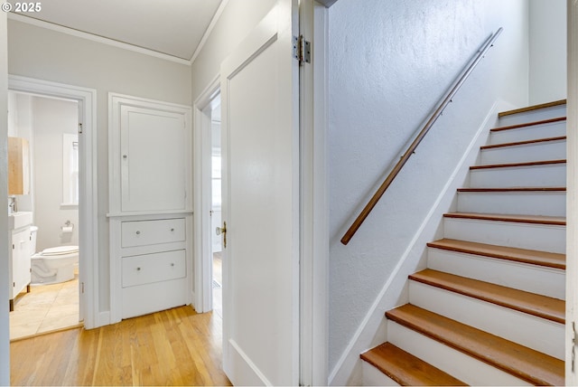 staircase featuring ornamental molding and hardwood / wood-style floors