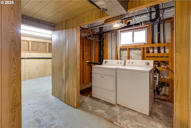 washroom with wooden walls and independent washer and dryer