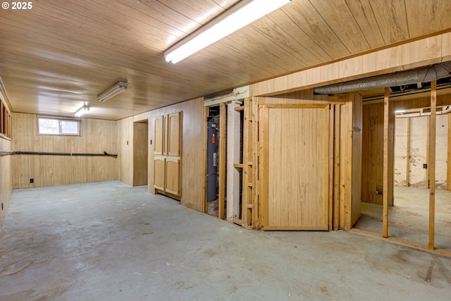 basement with water heater and wood walls