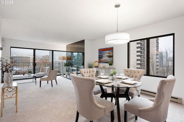 carpeted dining room featuring a baseboard heating unit and plenty of natural light