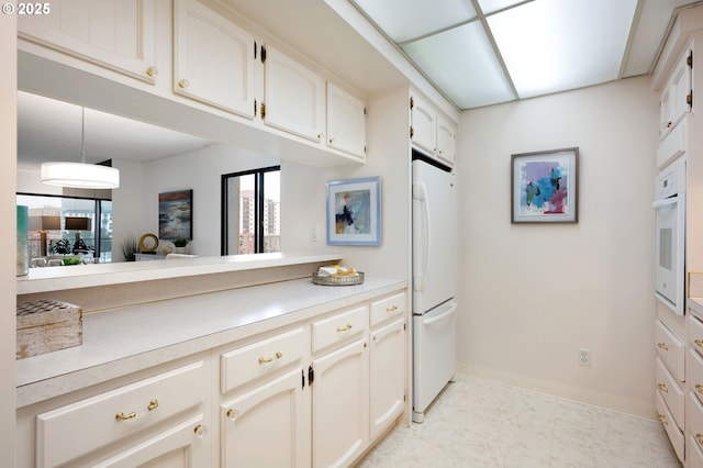 kitchen featuring white appliances and hanging light fixtures