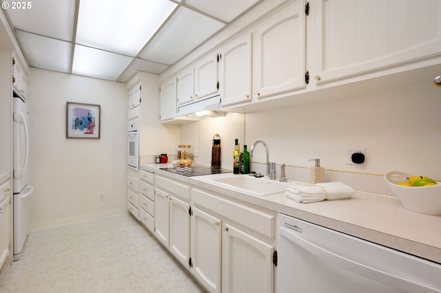 kitchen with white appliances, white cabinetry, a paneled ceiling, and sink