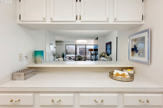 kitchen featuring a wall mounted AC and white cabinetry