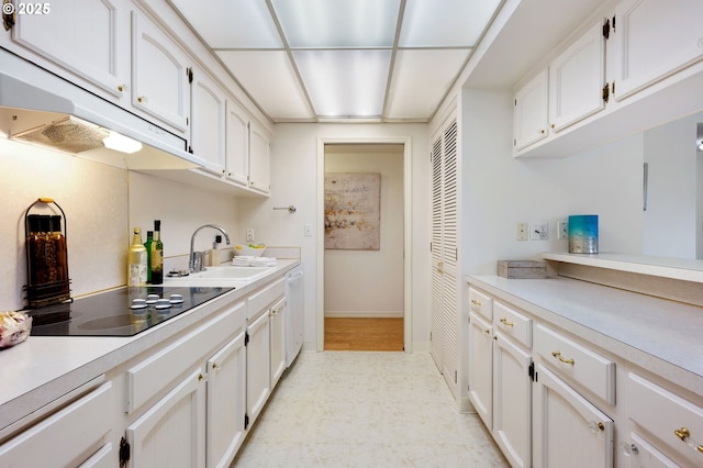 kitchen with sink, black electric cooktop, white dishwasher, and white cabinetry