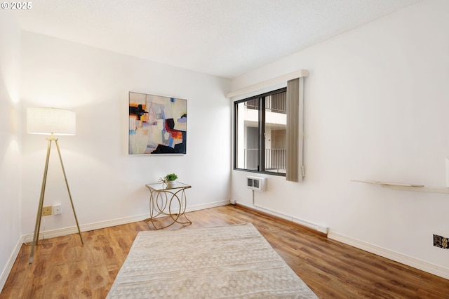 empty room with a wall unit AC and hardwood / wood-style flooring