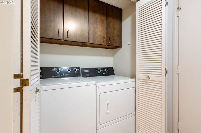 laundry room featuring washer and dryer and cabinets