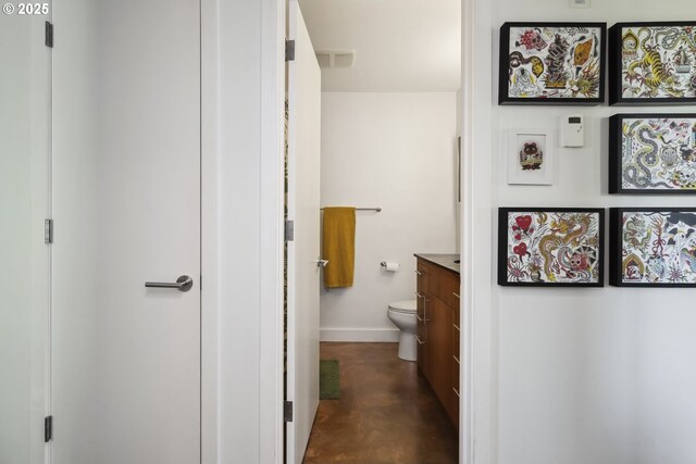 325 NE Graham St Unit 8, Portland, OR 97212 - bathroom with concrete flooring, vanity, baseboards, and toilet