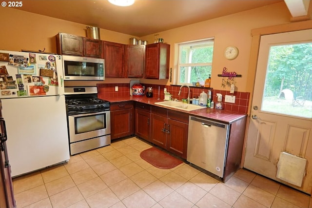 66663 Gunderson Rd, North Bend, OR 97459 - kitchen with stainless steel appliances, tile countertops, backsplash, and light tile patterned floors