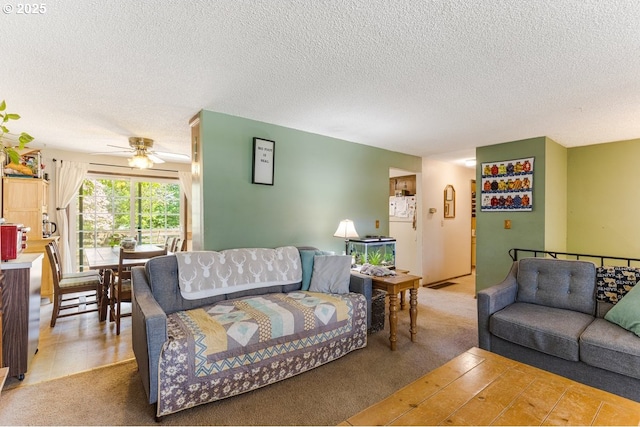 living area with light colored carpet, a ceiling fan, and a textured ceiling