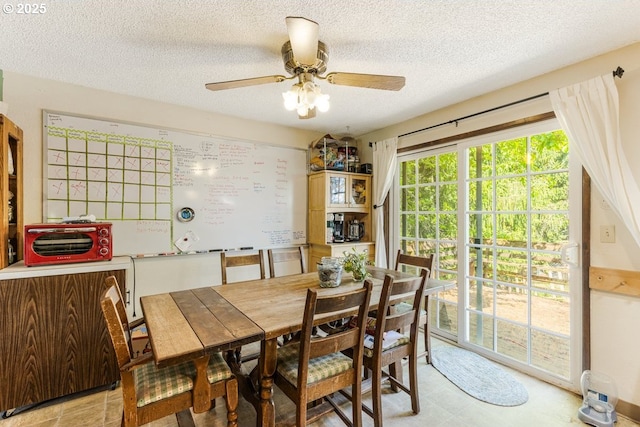 dining area featuring ceiling fan and a textured ceiling