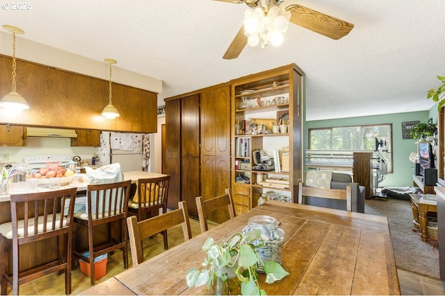 dining area featuring a textured ceiling and ceiling fan