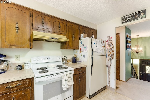 kitchen featuring light countertops, under cabinet range hood, white appliances, and a textured ceiling