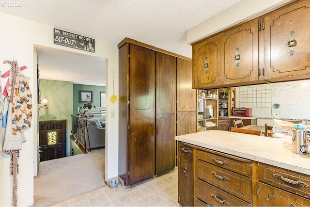 kitchen featuring light countertops, brown cabinets, and a textured ceiling