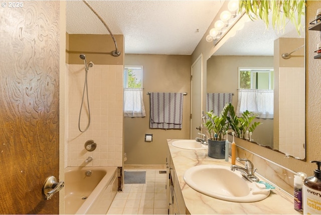 full bathroom with shower / bath combination, a sink, a textured ceiling, and tile patterned floors