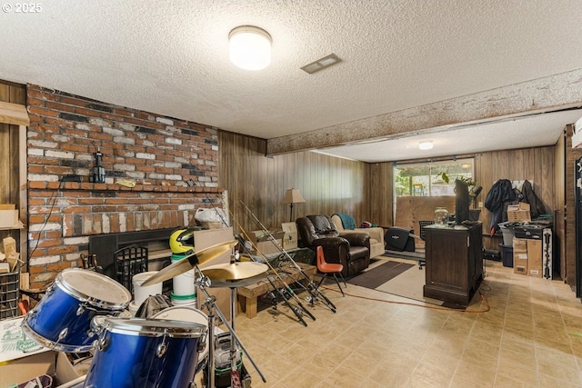 interior space featuring wood walls, a textured ceiling, and tile patterned floors