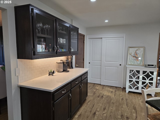 bar featuring backsplash and light hardwood / wood-style flooring