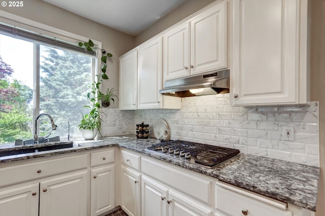 15463 NW Andalusian Way, Portland, OR 97229 - kitchen featuring under cabinet range hood, stainless steel gas cooktop, a sink, white cabinetry, and decorative backsplash