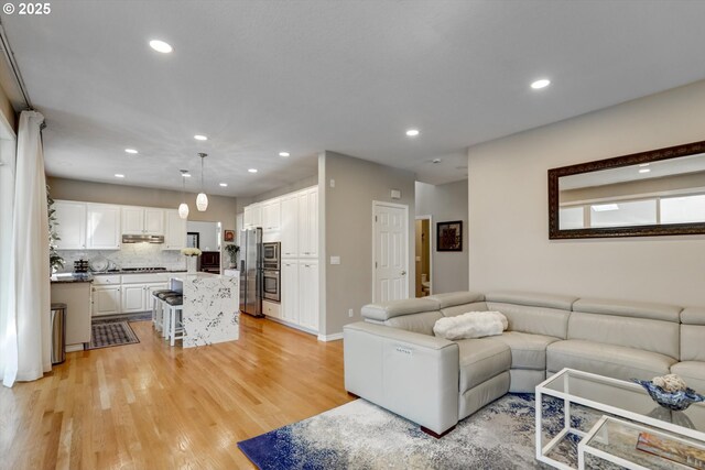 15463 NW Andalusian Way, Portland, OR 97229 - living room featuring recessed lighting, light wood-type flooring, and baseboards