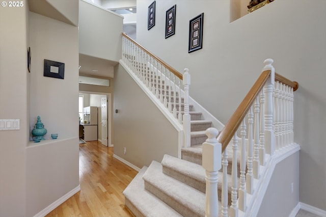 15463 NW Andalusian Way, Portland, OR 97229 - stairs featuring wood finished floors, baseboards, and a high ceiling