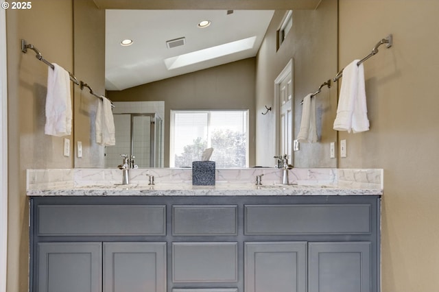 15463 NW Andalusian Way, Portland, OR 97229 - bathroom featuring vaulted ceiling, a skylight, a shower stall, double vanity, and recessed lighting