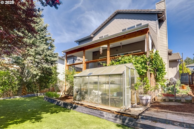 15463 NW Andalusian Way, Portland, OR 97229 - back of property with a greenhouse, a lawn, an outdoor structure, a chimney, and a garden