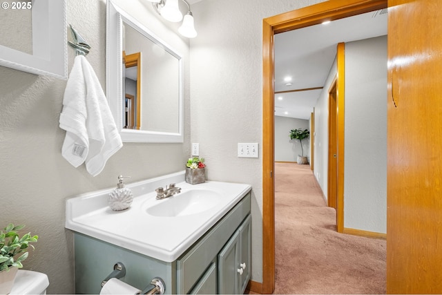 1313 Wakeman Ln, Gearhart, OR 97138 - half bathroom featuring vanity, toilet, a textured wall, and baseboards