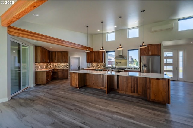 760 Carter St SW, Bandon, OR 97411 - kitchen featuring high end fridge, a large island with sink, decorative backsplash, dark wood-style floors, and light countertops