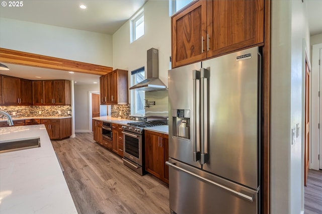 760 Carter St SW, Bandon, OR 97411 - kitchen featuring stainless steel appliances, wall chimney exhaust hood, a sink, decorative backsplash, and recessed lighting