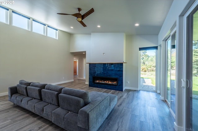 760 Carter St SW, Bandon, OR 97411 - living room with a ceiling fan, baseboards, wood finished floors, a tiled fireplace, and recessed lighting
